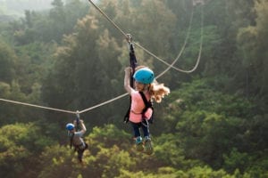 A girl and her father ziplining in Oahu.
