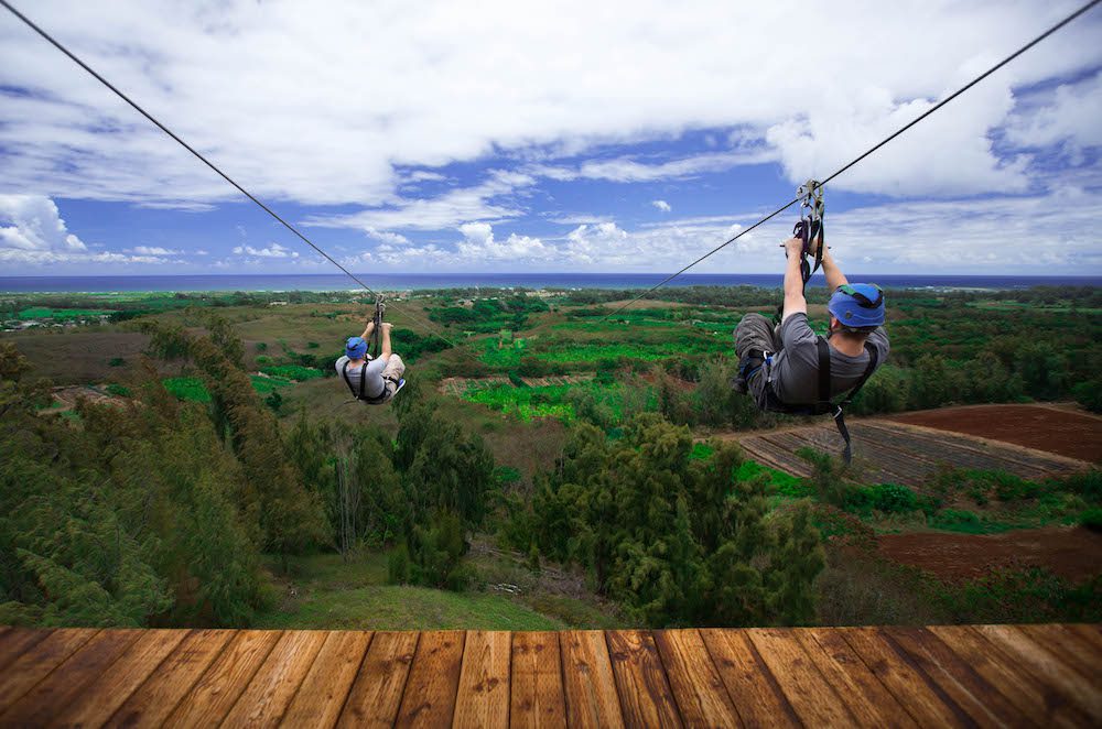 Two guys ziplining in Oahu at CLIMB Works Keana Farms.