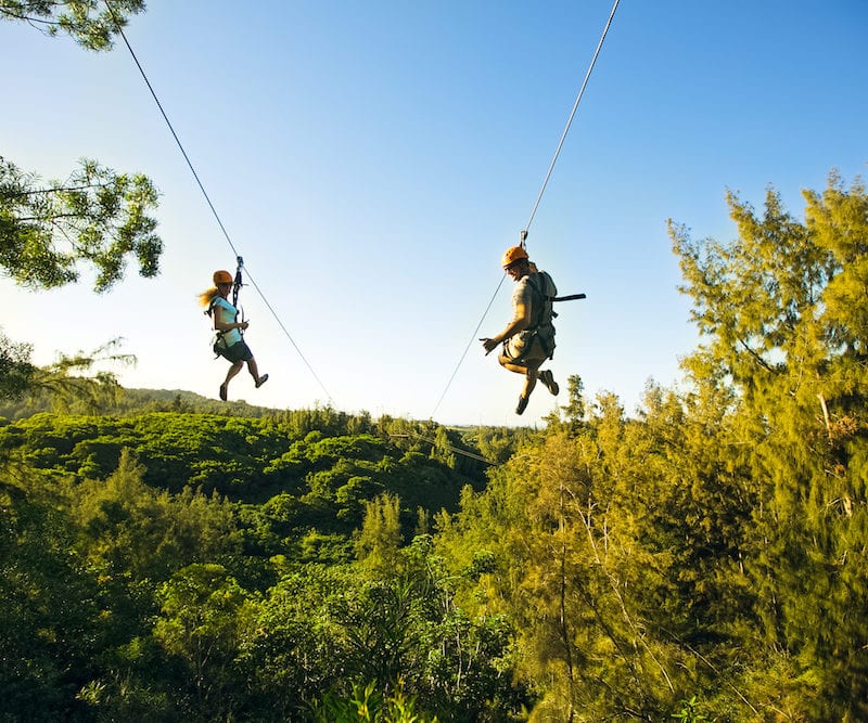 A couple riding one of our ziplines in Oahu.