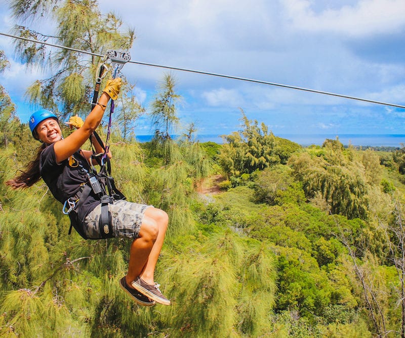 A smiling woman riding one of our Oahu ziplines.