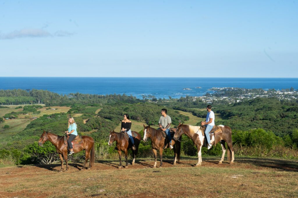 A group of people on horseback look at the stunning shorelines of the North Shore at Gunstock Ranch