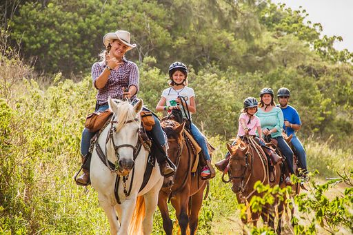 A guide leads a family on a horse back tour through the North Shore