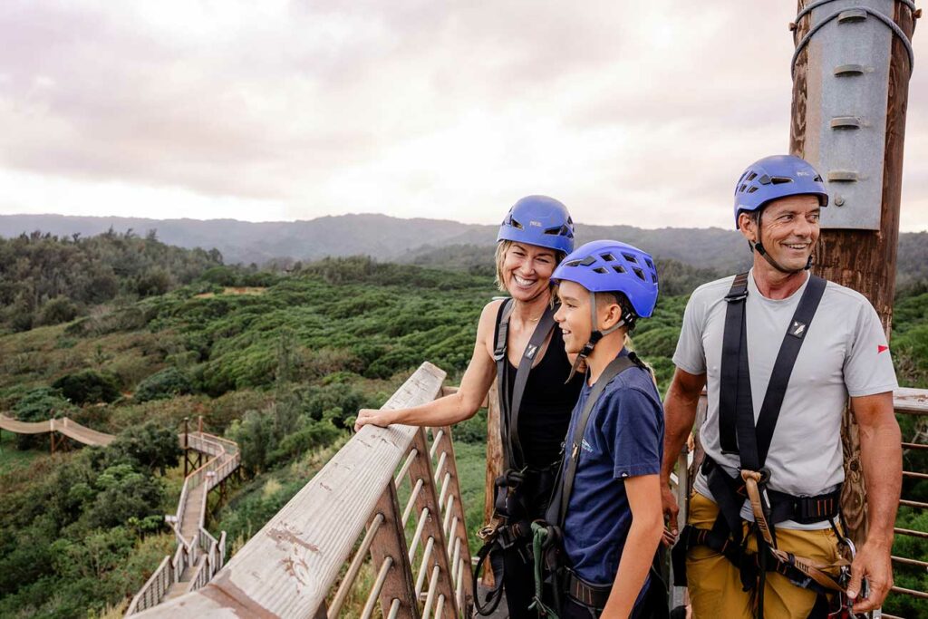 A family enjoys the scenic ocean, mountain, and farm views at CLIMB Works from a zipline platform