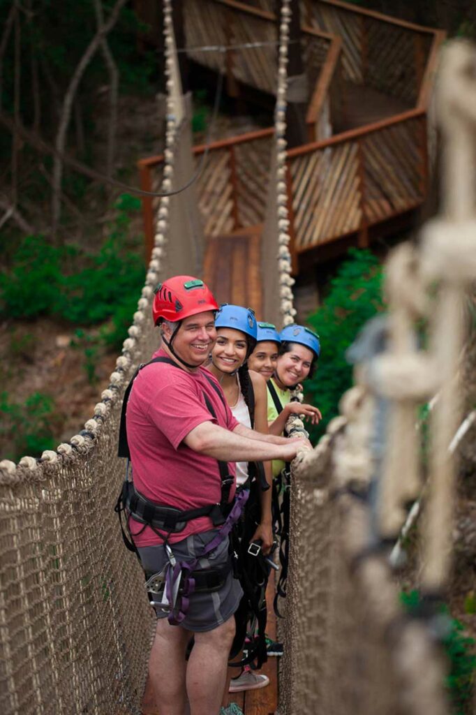 A family smiles as they enjoy a skybridge at CLIMB Works