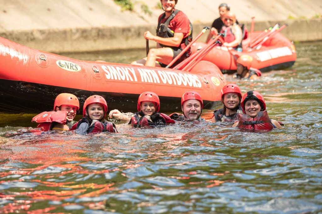 A family of rafters enjoys a refreshing cool off in a river with Smoky Mountain Outdoors