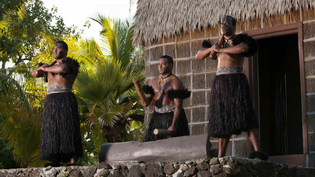 Men in traditional Fijian clothing perform for guests in the Fiji Village at the PCC