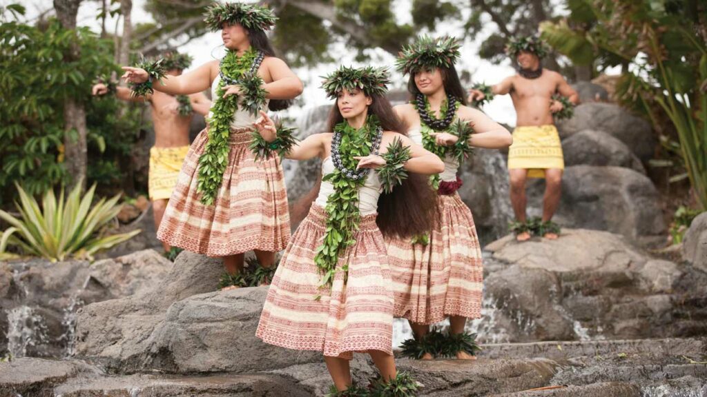 Hula dancers staggered across a rocky landscape stage perform a traditional Hula