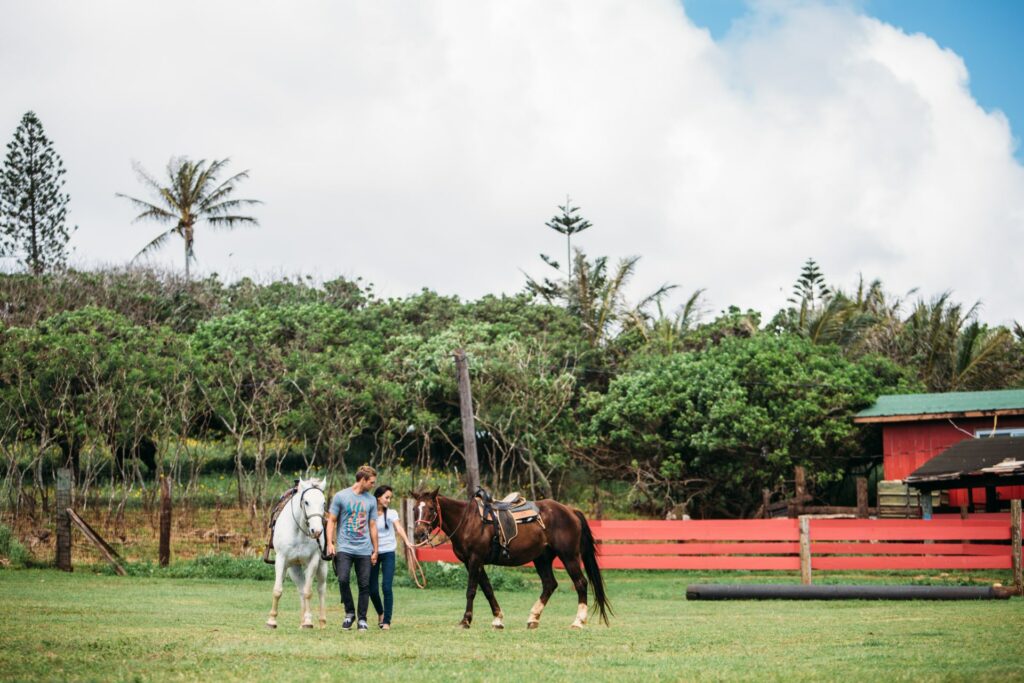 A couple lead their horses near the stables at Gunstock Ranch