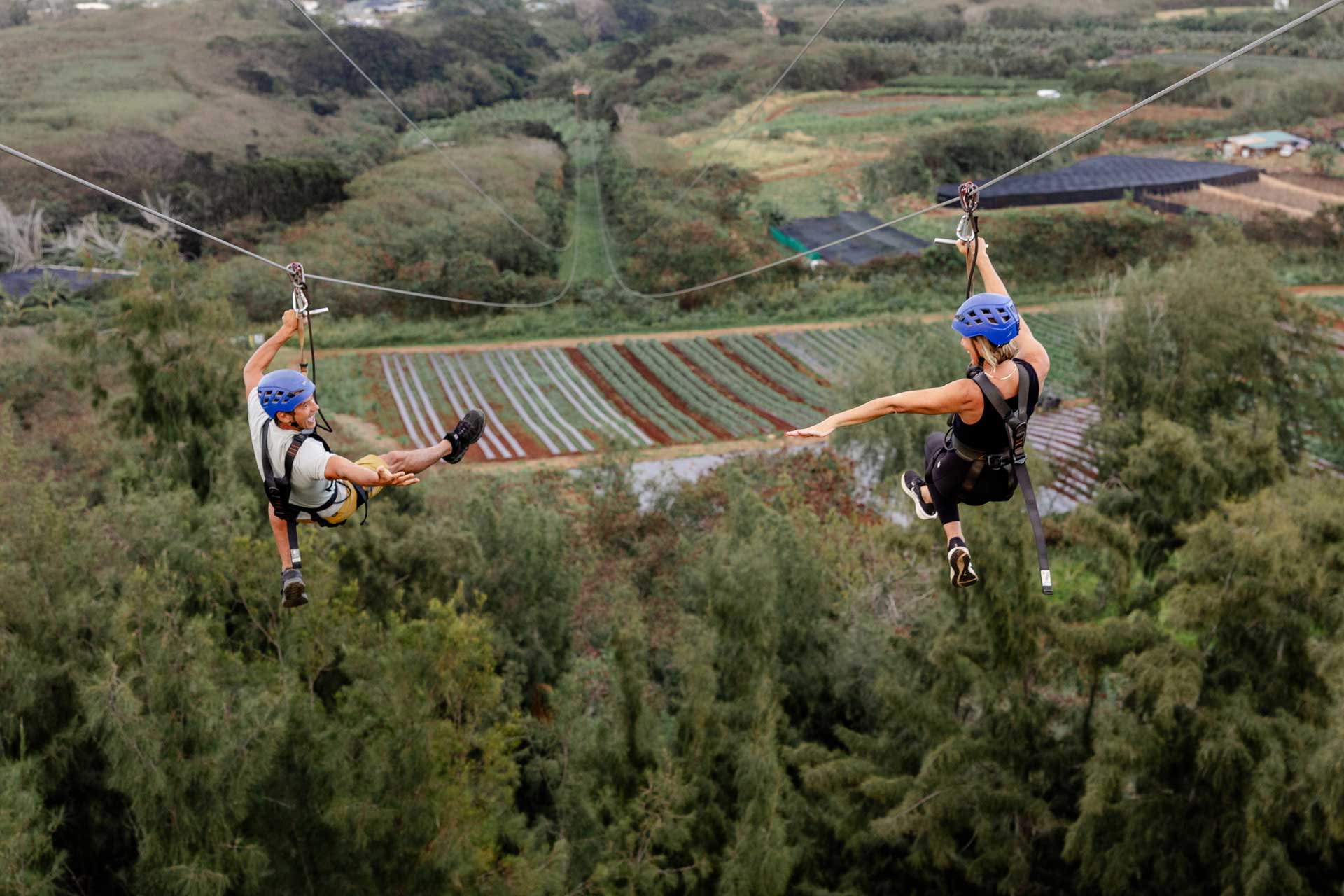 A couple zip lining side-by-side