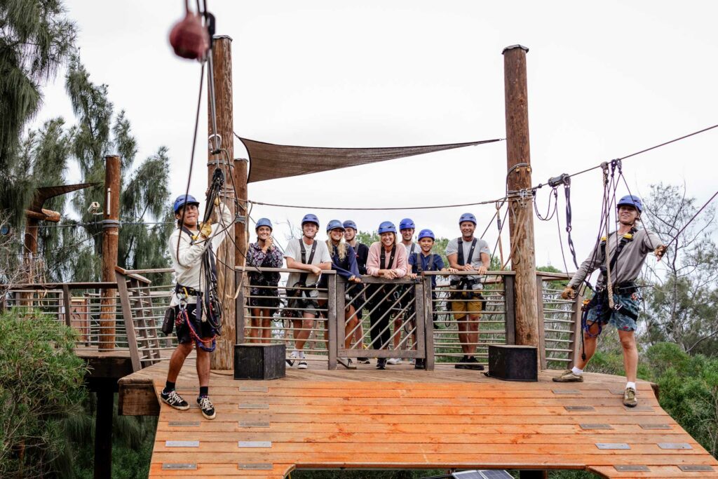 A happy zipline tour group standing on a platform at CLIMB Works Hawai‘i