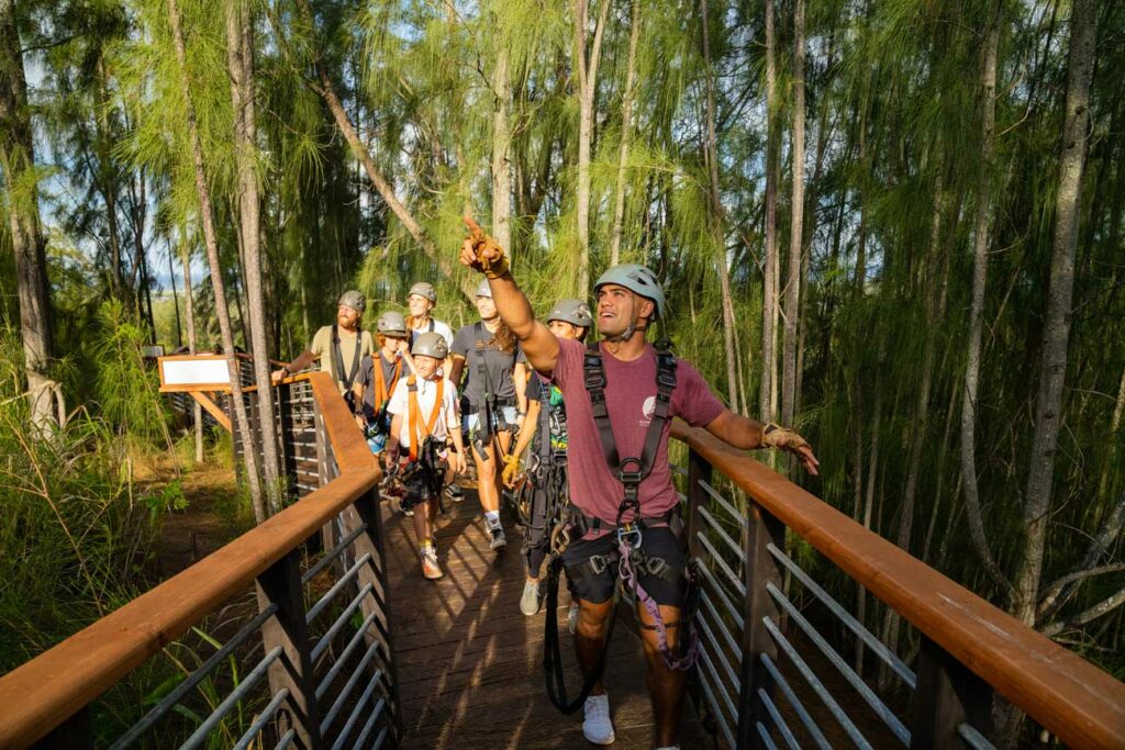 Tour guide leads group across CLIMB Works tour. Group walking on elevated boardwalk.