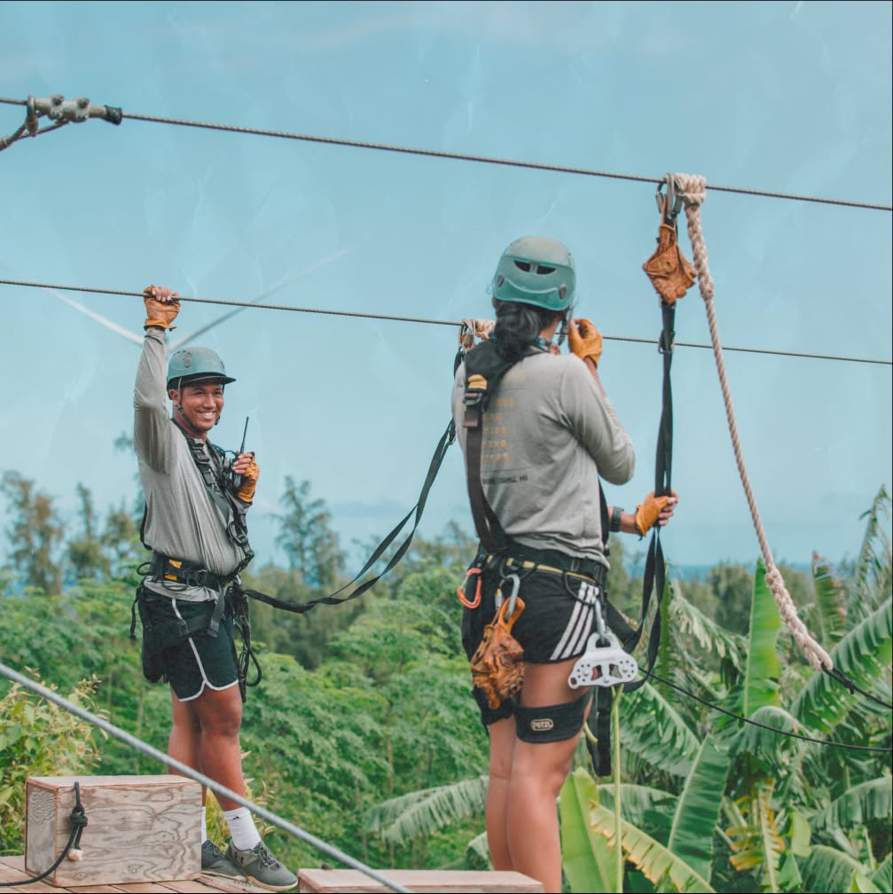 Zipline Tour Guides cheerfully waiting on guests to zip a line over a Hawaiian farm