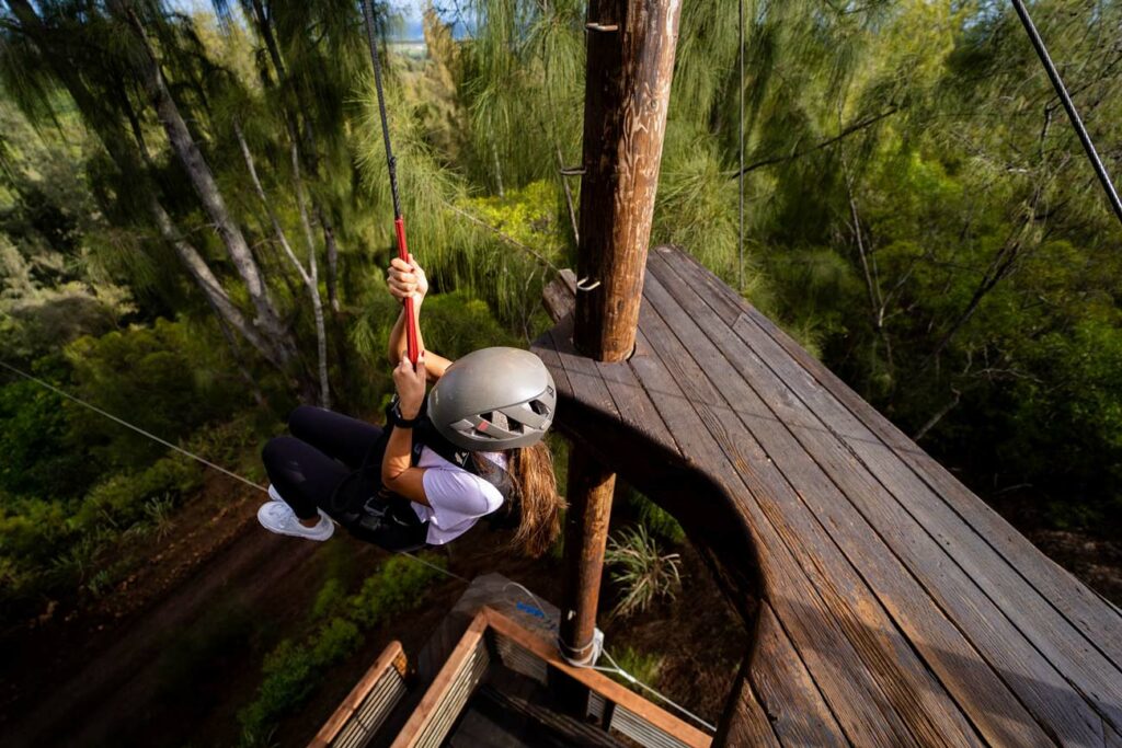 A woman rappelling from a high platform at CLIMB Works Keana Farms